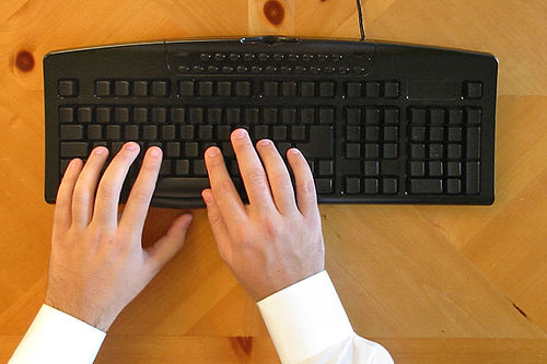 man typing on keyboard