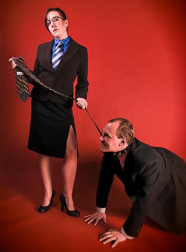 woman pulling man by tie