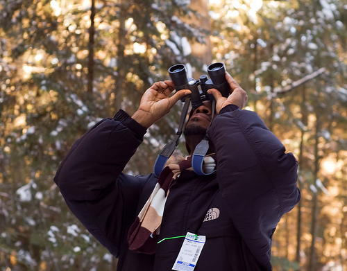 man looking through binoculars